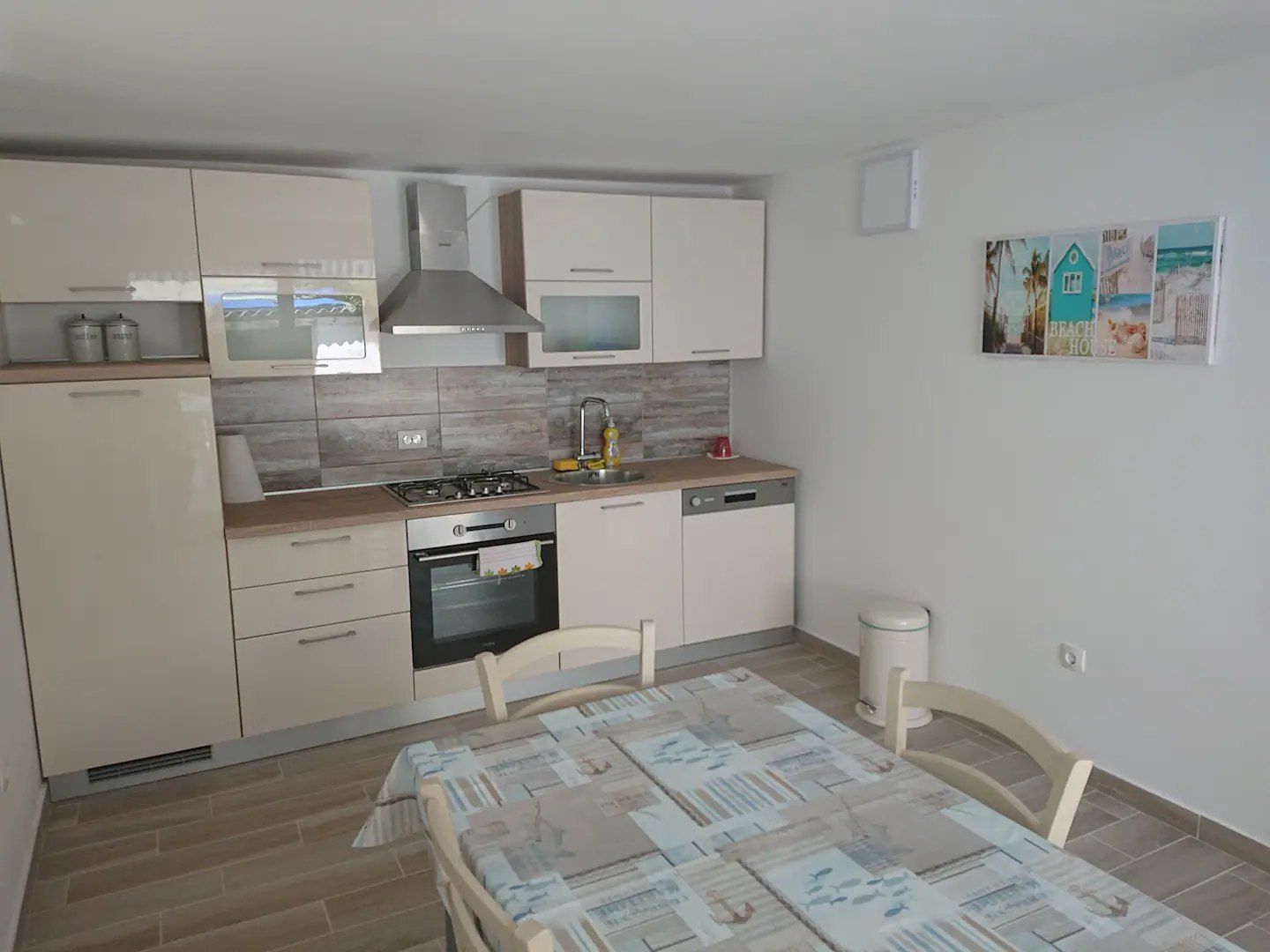 Kitchen with cream units, an oven and a dining table