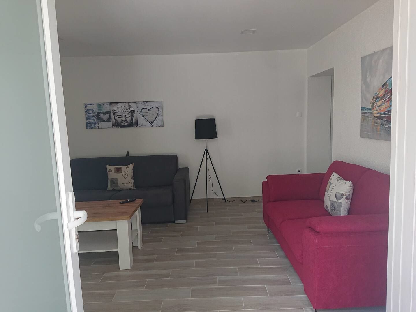 Living room with a grey sofa, a red sofa and a coffee table