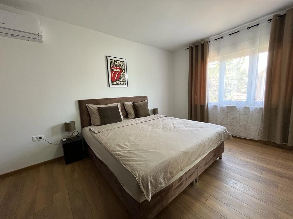 First bedroom with a queen-size bed and long curtains