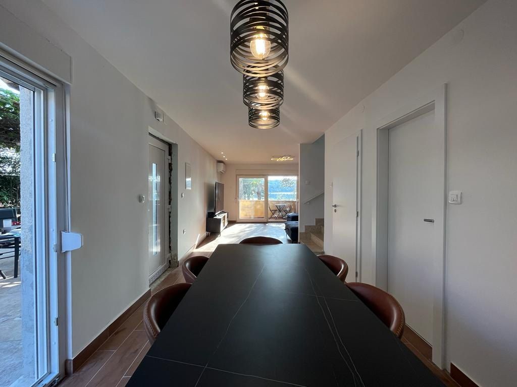 Long dining table under pendant lights in the open ground floor