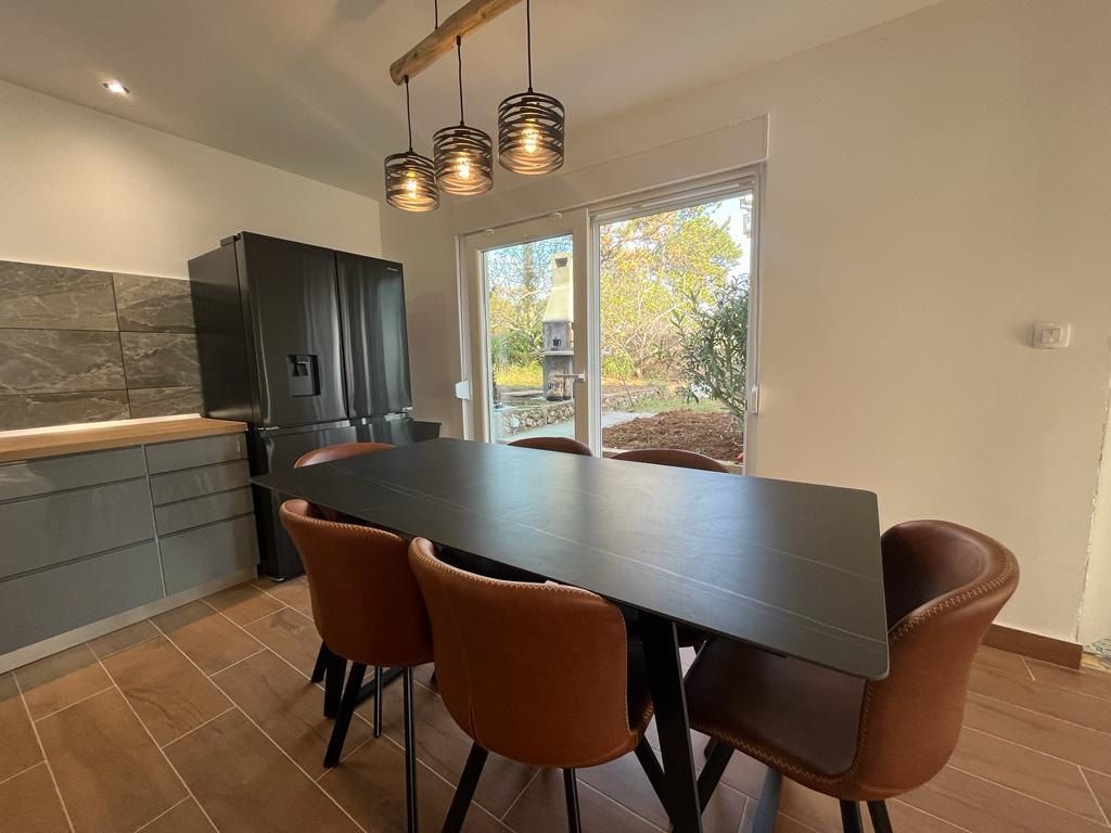 Dining table with leather chairs next to the kitchen