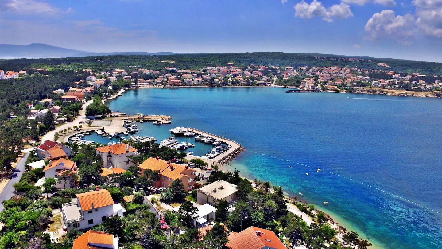 Aerial view of Šilo bay on the island of Krk, with the marina, red roofs and turquoise water
